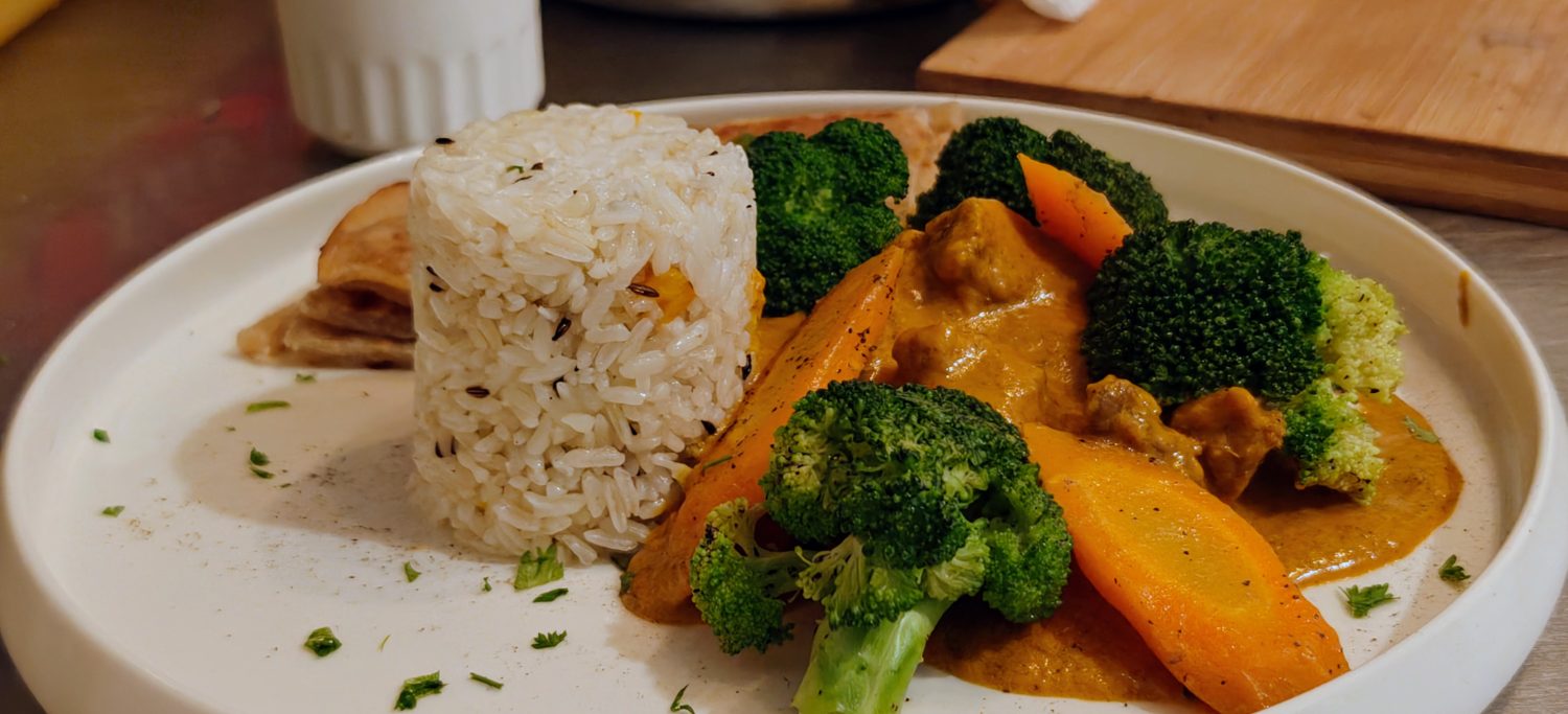 Beef curry with steamed broccoli, carrots and cumin rice