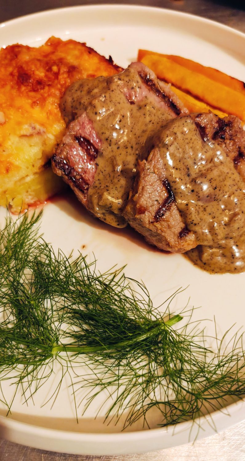 Char-grilled steak with peppercorn sauce and potato gratin