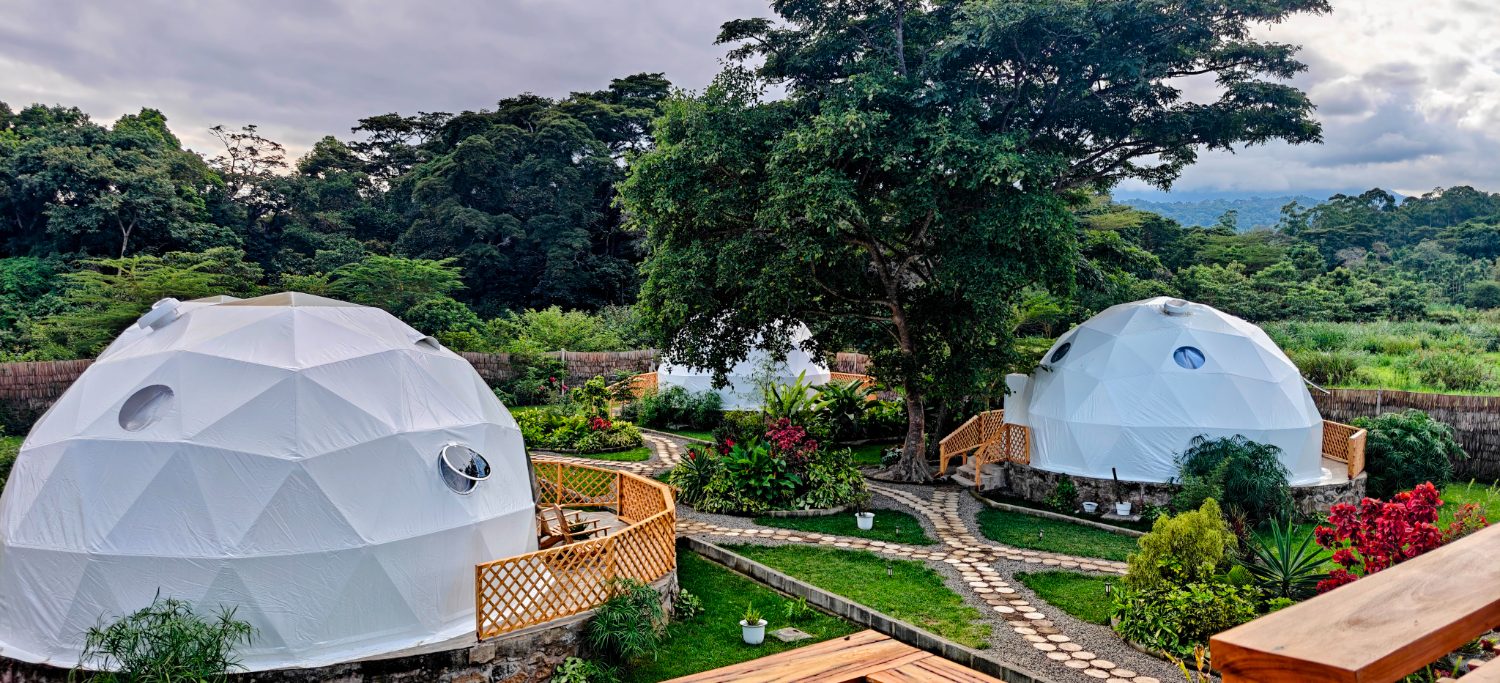 Two domes set in lush garden under Mount Meru